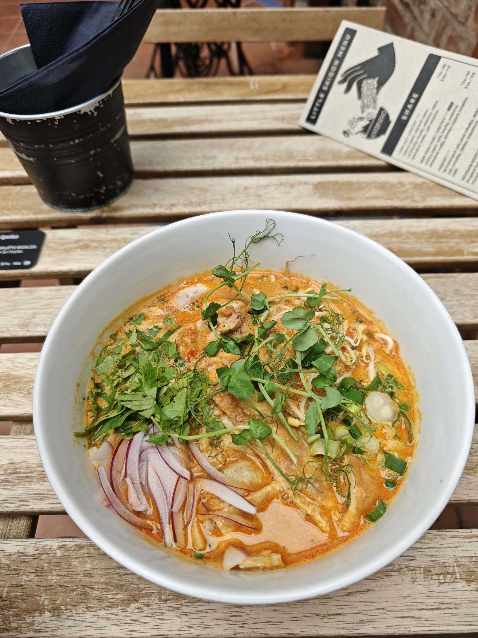 Voňavá laksa s nudlemi, bylinkami a červenou cibulí.